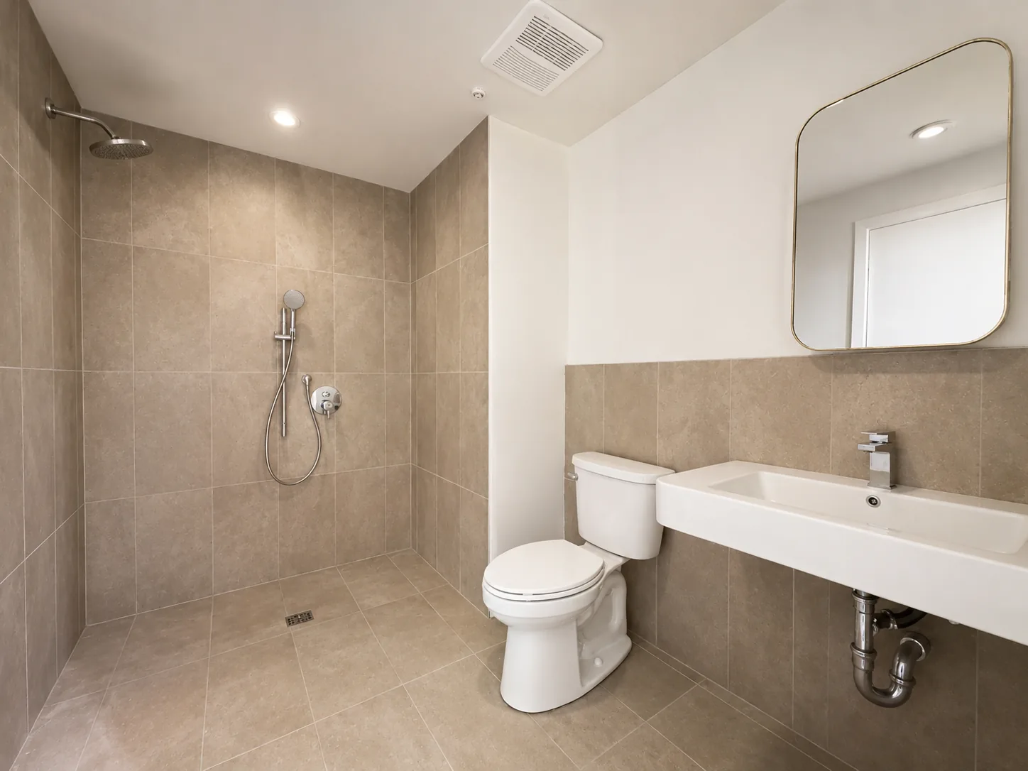Actual Unit 202 bathroom with walk-in shower, toilet, and vanity